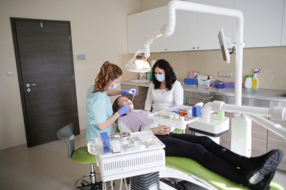 Dentista realizando atendimento odontológico em uma clínica